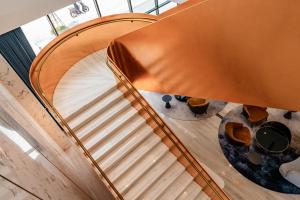 an overhead view of a wooden spiral staircase with a circular stair case at Mövenpick Living West Hanoi in Hanoi
