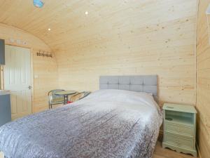 1 dormitorio con 1 cama y pared de madera en Beulah, en Axbridge