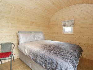 een slaapkamer met een bed in een houten hut bij Suffolk in Axbridge