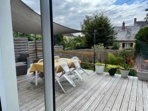 un patio con mesa y sillas en una terraza en Location maison Le Mans - Parking gratuit - CEMIMA en Le Mans