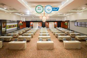 a large banquet hall with white tables and chairs at Hua Hin Grand Hotel and Plaza - SHA Extra Plus in Hua Hin