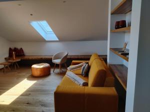 a living room with a yellow couch and a skylight at Gasthof Fischerstüberl in Rottau