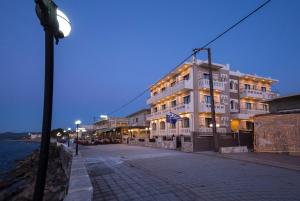 a building on a street near the water at night at Mandy Suites in Kissamos