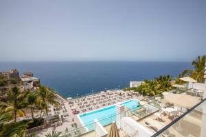 een balkon met uitzicht op het strand en de oceaan bij Hotel Altamar in Puerto Rico de Gran Canaria