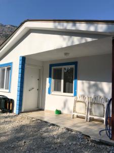 Likya Inn - Dodurga&Patara Evleri في Gâvurağılı: منزل أبيض وأزرق على شرفة