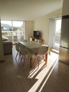 a dining room with a table and chairs and a refrigerator at Primera Linea de Playa Samil Costa con Garaje Incluido in Vigo