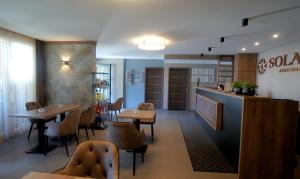 un restaurante con mesas y sillas y un bar en Solaris Apartman&Resort, en Cserkeszőlő