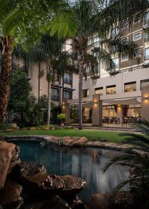 
a large swimming pool in front of a large building at Premier Hotel Pretoria in Pretoria
