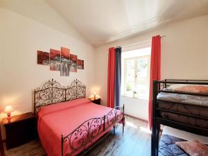 a bedroom with a red bed and a window at DIMORA IL CAMALEONTE, apartments in nature near the sea in Civitavecchia