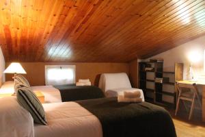 a bedroom with two beds and a wooden ceiling at Hostal l´Ou de Reig in Montseny