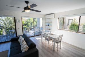 ein Wohnzimmer mit einem Sofa und einem Tisch in der Unterkunft Myuna Holiday Apartments in Noosa Heads