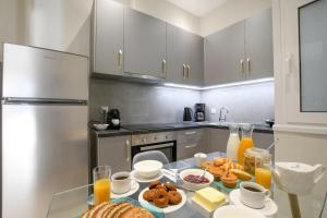 uma cozinha com uma mesa com alimentos para pequeno-almoço e sumo de laranja em Sunset Luxury Suite - Rooftop Apartment in the City Center em Heraclião
