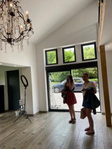 two women standing in a room with a camera at La grange de Livia in Ferrière-la-Grande