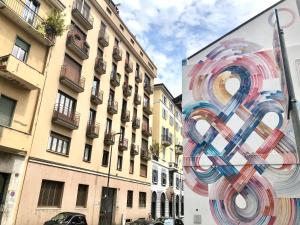 una gran pintura de un símbolo en el lateral de un edificio en Marco Polo GreenRoom en Milán