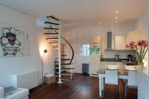 a kitchen and dining room with a table and a staircase at Smederij Schoorldam in Schoorl