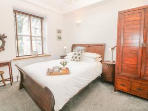 a bedroom with a large bed with a wooden headboard at Ardeevin Cottage in Buxton