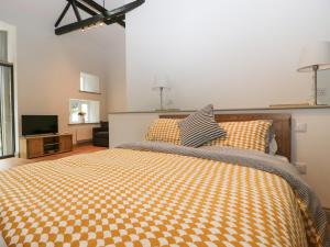a bedroom with a large bed and a television at The Coach House in Horton