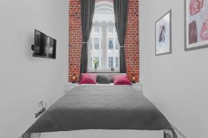 een groot bed in een kamer met een raam bij Roulette in Wrocław