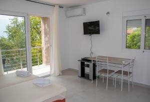 a white living room with a table and a balcony at Bay Leaf Apartments in Kotor
