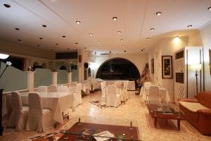 a banquet hall with white tables and white chairs at Galini Palace in Athens