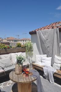 eine Terrasse mit Sofas und einem Tisch mit Weingläsern in der Unterkunft Maison du Flâneur in Chioggia