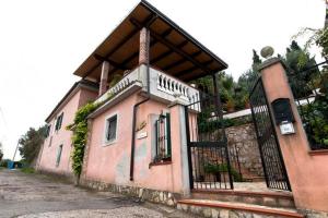 villa la camargue في جيتا: مبنى صغير وردي اللون به شرفة