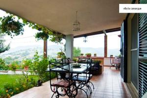 villa la camargue في جيتا: فناء مع طاولة وكراسي على شرفة