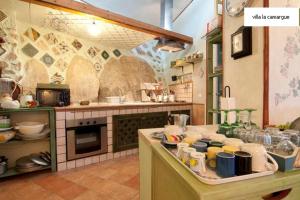 villa la camargue في جيتا: مطبخ مع كونتر عليه العديد من الأطباق +40 صورة