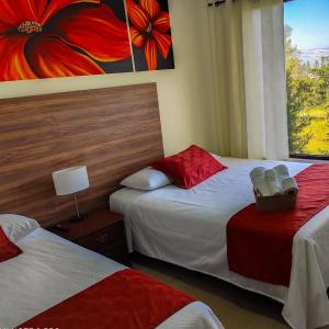 a hotel room with two beds and a window at Hotel Las Mercedes Airport-Quito in Tababela