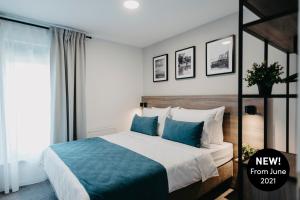 sypialnia z dużym łóżkiem z niebieskimi poduszkami w obiekcie Premium Apartments Terme Sveti Martin w mieście Sveti Martin na Muri