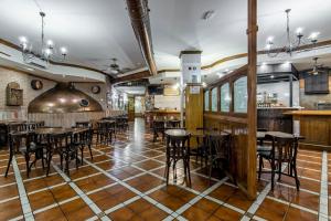 a restaurant with wooden floors and tables and chairs at HOTEL DON RAMIRO in Montilla
