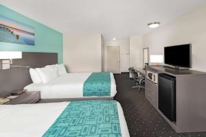 um quarto de hotel com duas camas e uma televisão de ecrã plano em Howard Johnson by Wyndham Gananoque em Gananoque