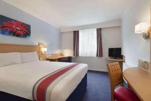 una camera d'albergo con letto e scrivania di Ramada Wakefield a Wakefield