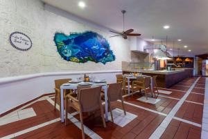 una sala da pranzo con tavoli e sedie e una cucina di Cozumel Hotel & Resort a Cozumel Altre 89 foto