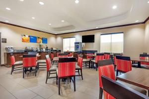 a restaurant with red chairs and tables and a bar at Comfort Inn Near UNT in Denton