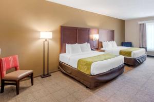 a hotel room with two beds and a chair at Comfort Suites St George - University Area in St. George