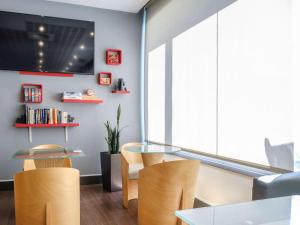 a dining room with a glass table and chairs at Ibis Madrid Alcobendas in Alcobendas