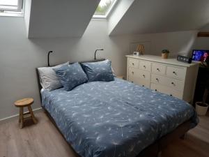 1 dormitorio con 1 cama con sábanas azules y vestidor en Bed & Breakfast Beilerhorst, en Beilen