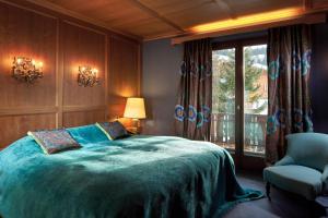 ein Schlafzimmer mit einem Bett, einem Stuhl und einem Fenster in der Unterkunft Kristiania Lech in Lech am Arlberg