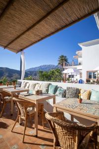 a patio with tables and chairs and a view at Malaga Hills Double Comfort Boutique & Wellness Hotel -Adults Only- in Cómpeta