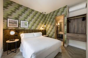 Un dormitorio con una gran cama blanca y una mesa en Mante House - Malasaña Design, en Madrid