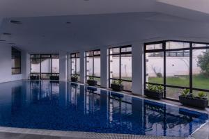 a swimming pool in a building with windows at Hotel Orbel in Dobrinishte