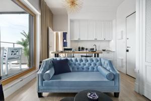 a blue couch in a living room with a kitchen at Nadmotławie Sauna & Gym by Blue Mandarin in Gdańsk
