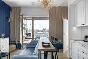a kitchen and dining room with a blue couch and a table at Nadmotławie Sauna & Gym by Blue Mandarin in Gdańsk