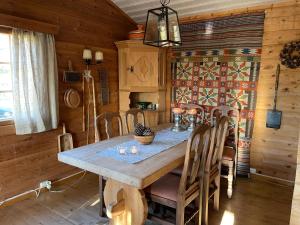 a dining room with a wooden table and chairs at Bjørnehiet Havsdalen in Geilo