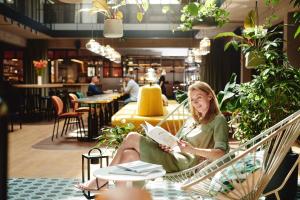 a woman sitting in a hammock reading a book at Hotel Gilbert in Vienna