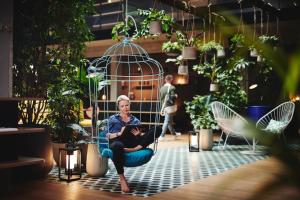 a woman sitting in a chair in a room filled with plants at Hotel Gilbert in Vienna
