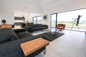 a living room with a couch and a table at Black Barn Skye - Contemporary 3 bed / 4 bath home in Broadford
