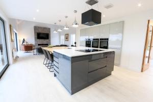 a kitchen with a island in the middle of a room at Black Barn Skye - Contemporary 3 bed / 4 bath home in Broadford