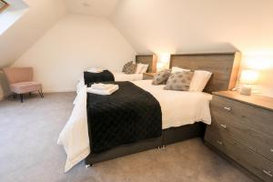 a bedroom with two beds in a attic at Black Barn Skye - Contemporary 3 bed / 4 bath home in Broadford